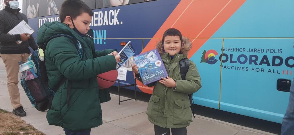 Two young boys holding books.