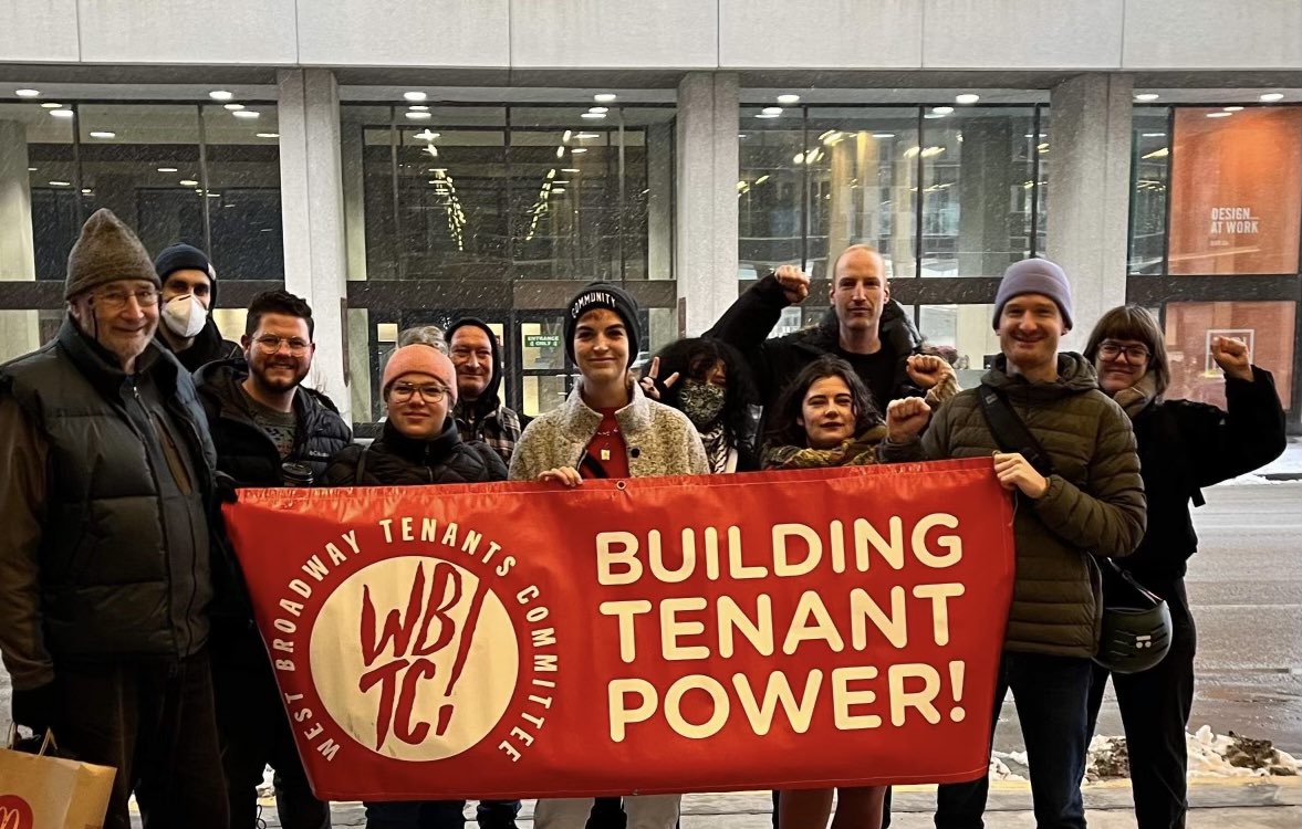 Tenants and organizers hold a banner that reads "Building Tenant Power!"
