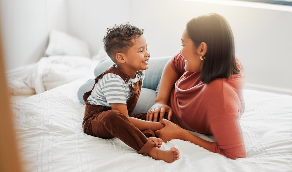 Mother talking with her son while resting in a sunny bedroom