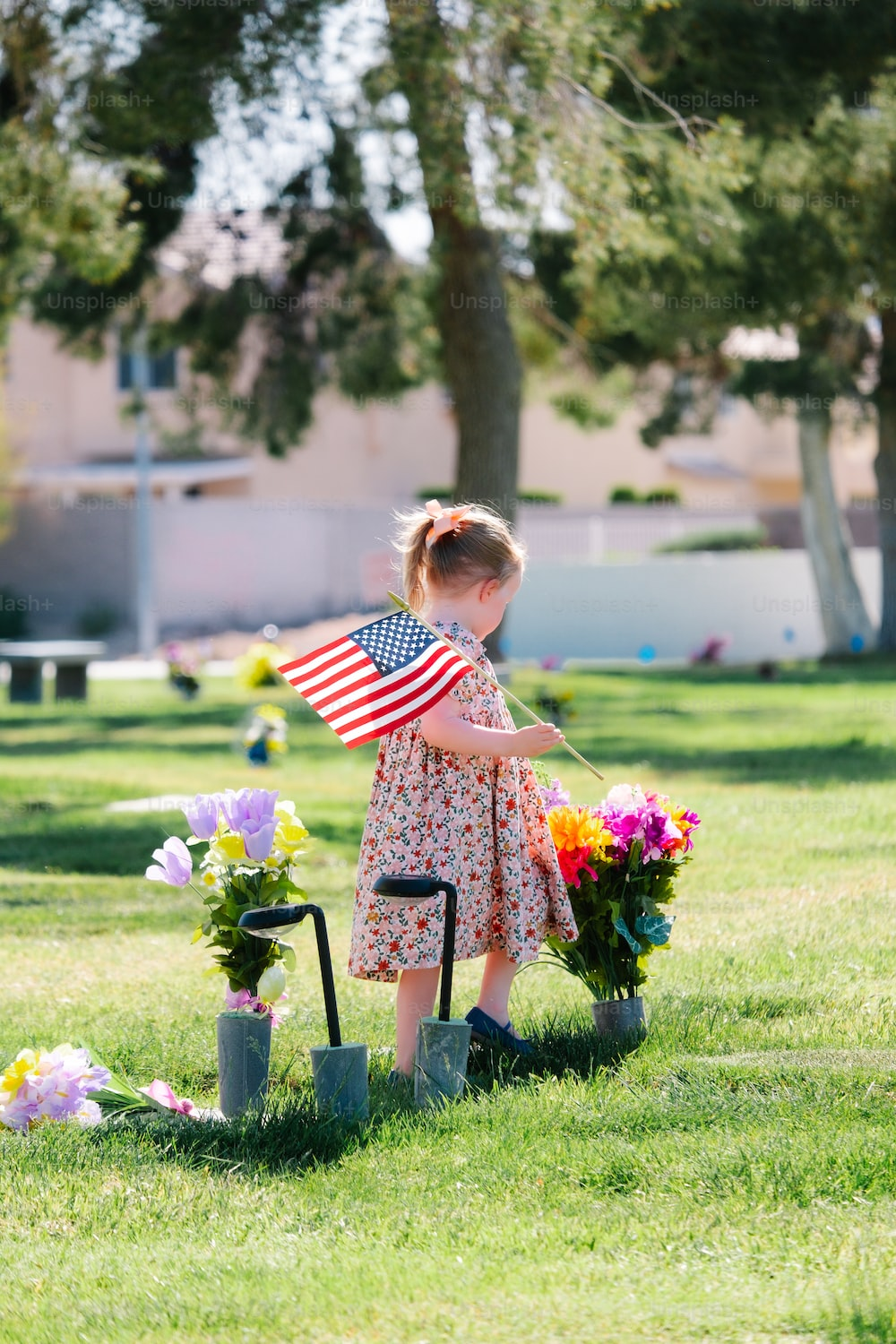 A little girl in a park holding the US flag