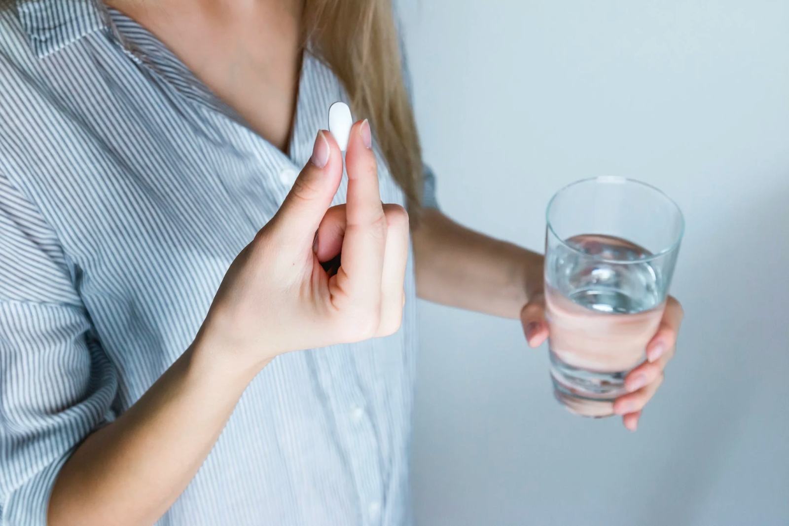 a woman about to take a pill of Benadryl