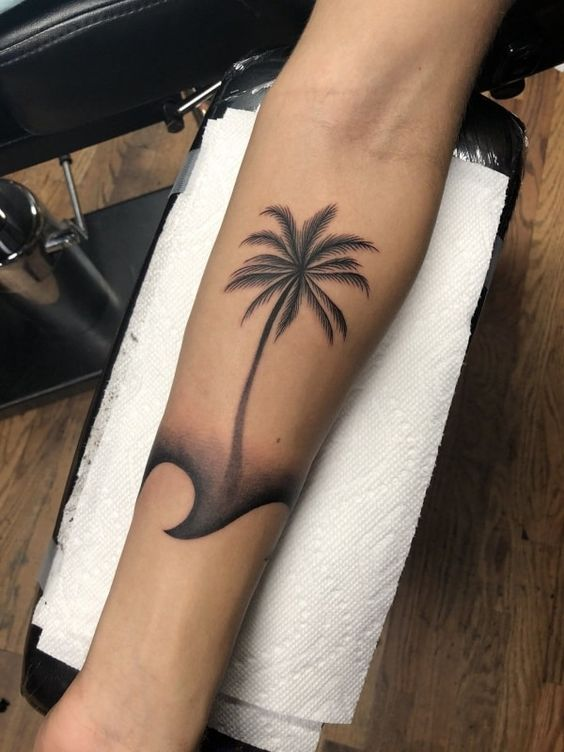 Full view of how a palm tree tattoo in a beach design looks like 