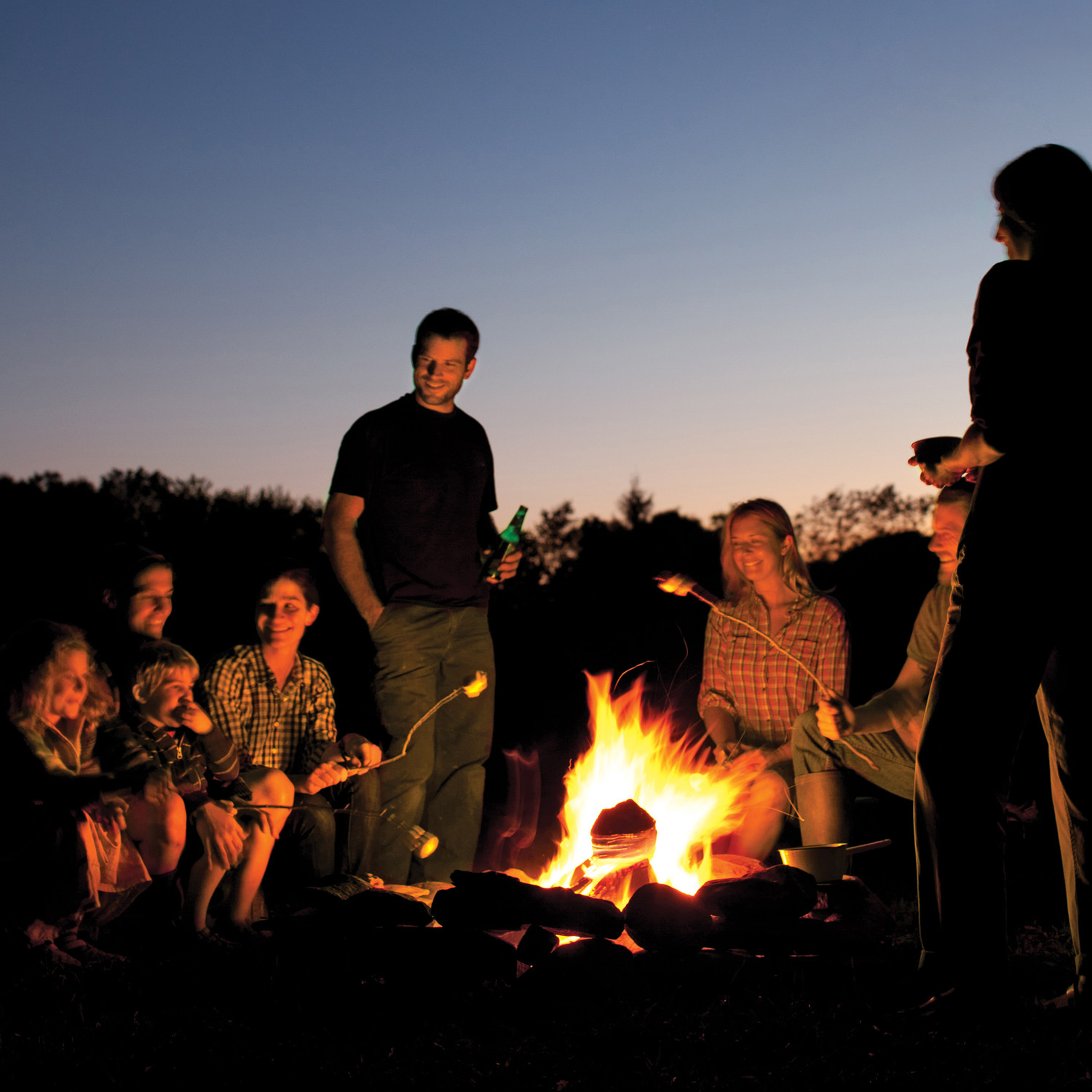 group roasting marshmallows by campfire