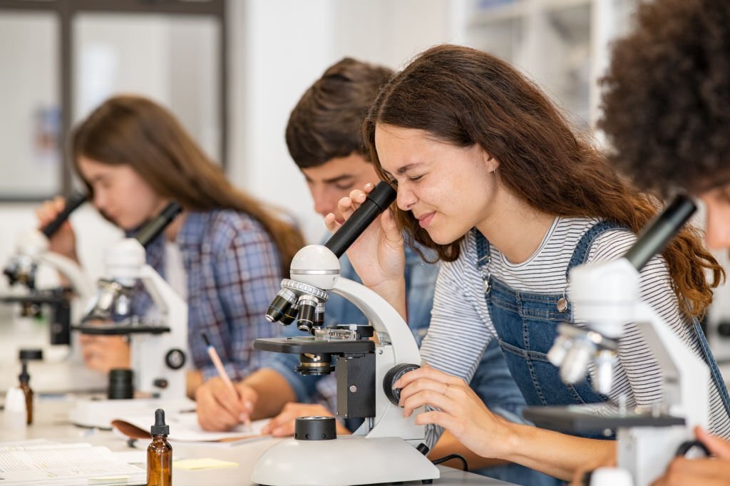 student looking into microscope.