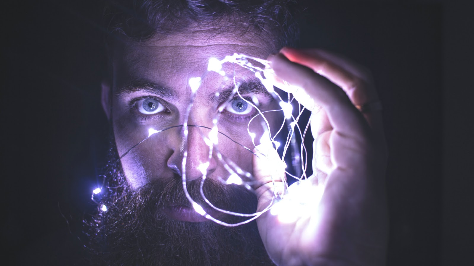 Bearded mad looking through a lighted orb to demonstrate the benefits of creatine supplementation on the brain 