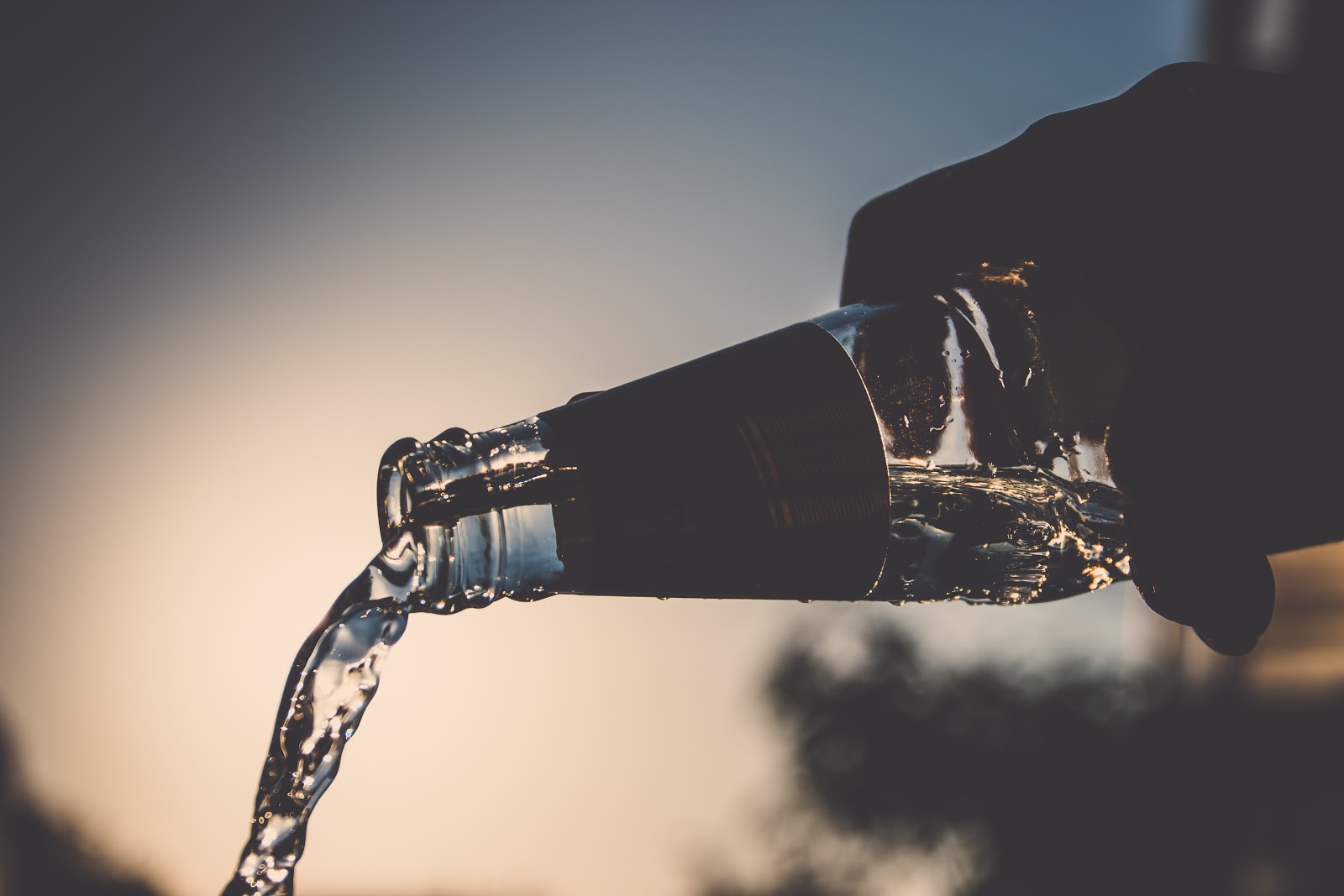 Hand pouring bottle of water