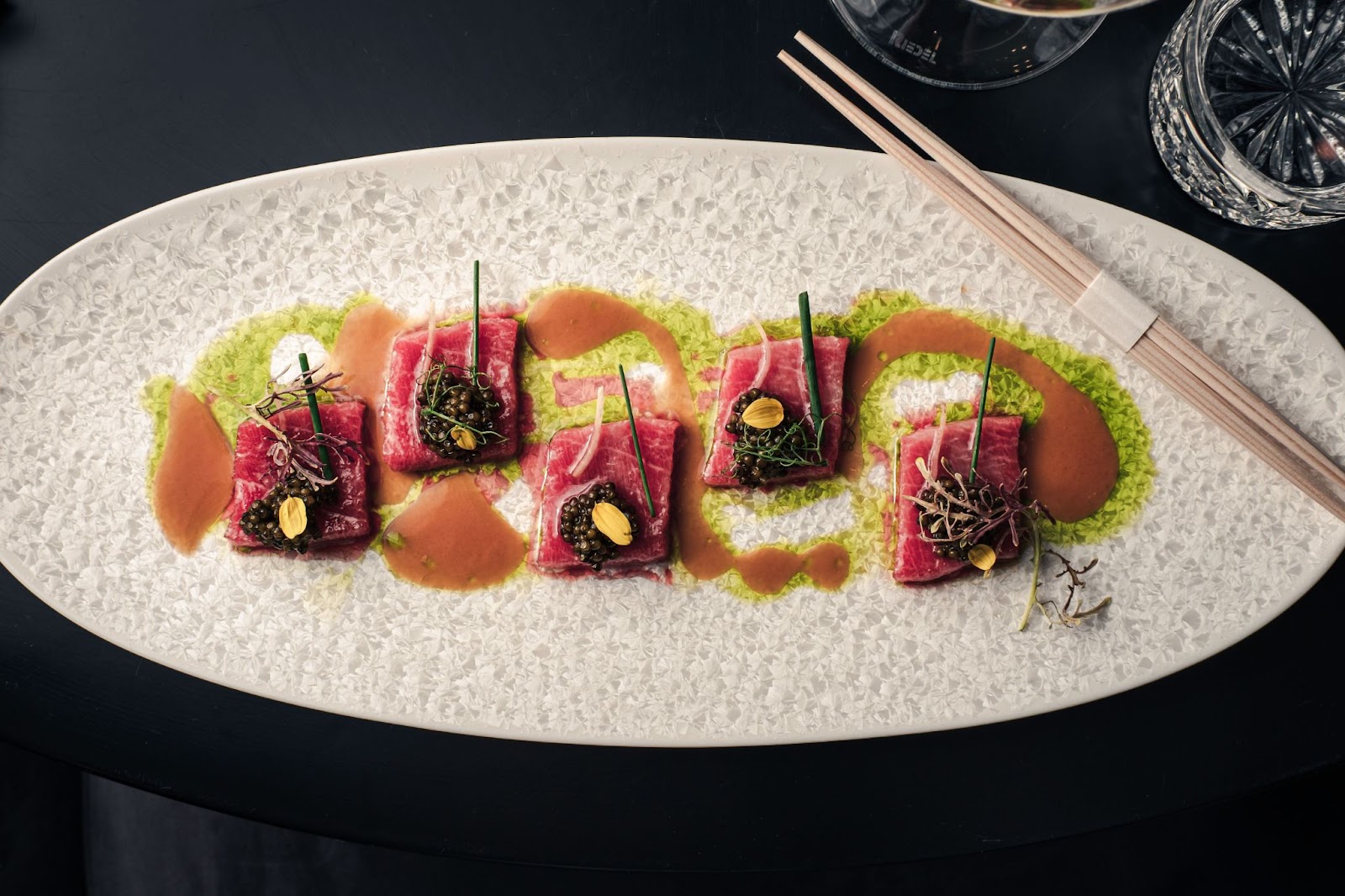 a photo of toro on a white plate with chopsticks from Caviar Bar