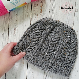 gray crochet hat lying flat on wooden background