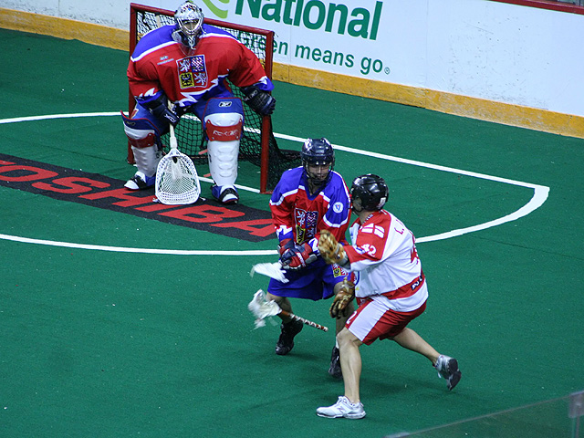 Player using basic lacrosse defense against an offensive opponent attacking the net.