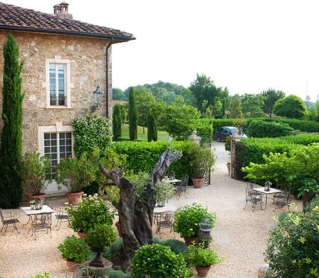 lateral garden with trees and tables at Borgo Santo Pietro Relais