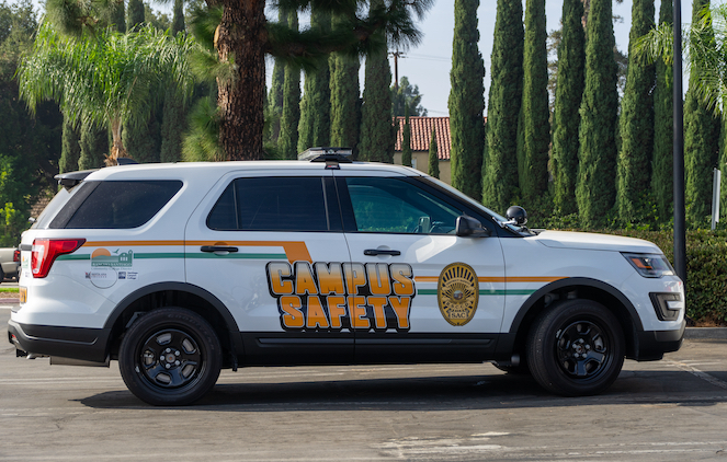 Campus safety car parked near some pine trees