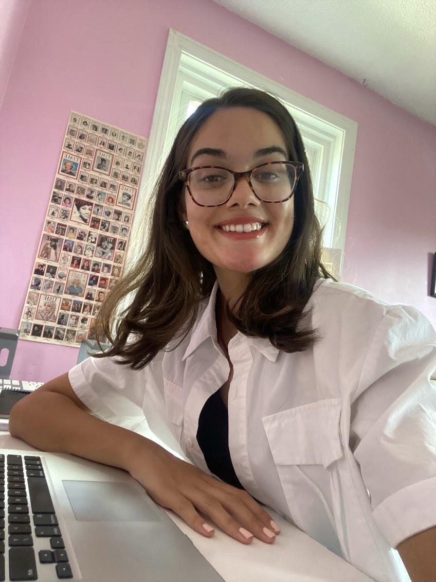 A person smiling and sitting in front of a computer

Description automatically generated with low confidence