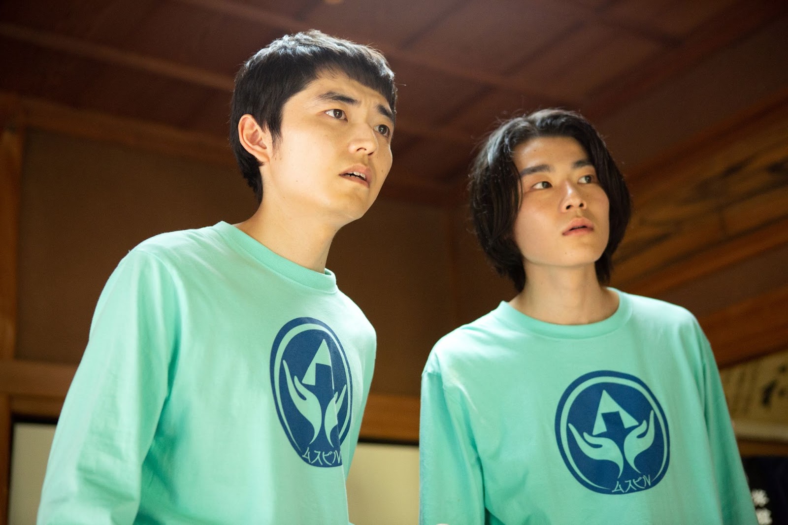 A screen still from Special Actors, depicting Kazuto and another young man wearing Special Actors shirts and looking in shock at something.