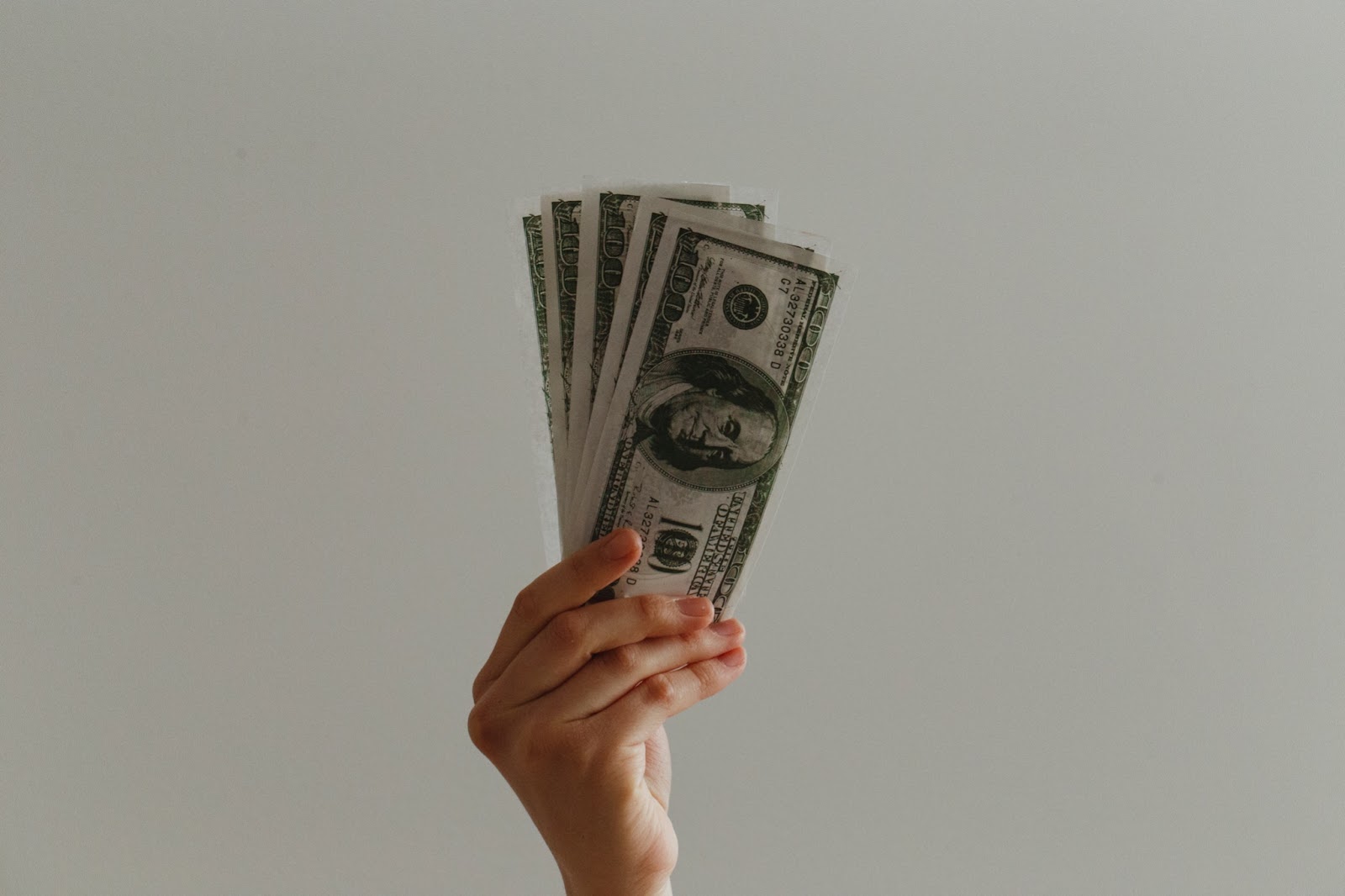 Person holding up a wad of cash