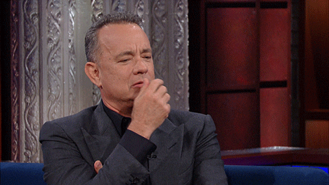 Tom Hanks rubs his face as he thinks.