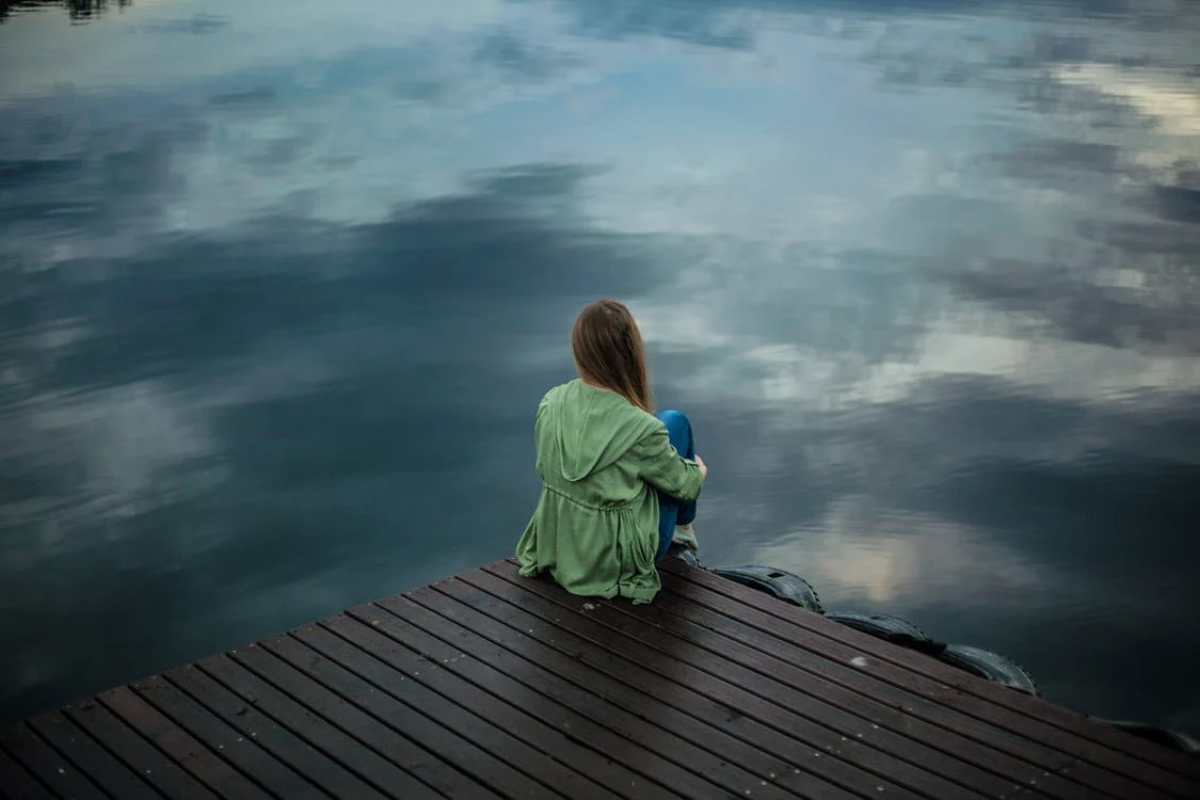 femeie pe pontonul unui lac
