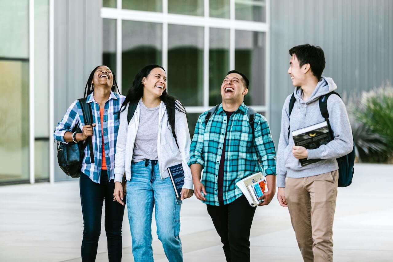 Students laughing while walking outside on campus
