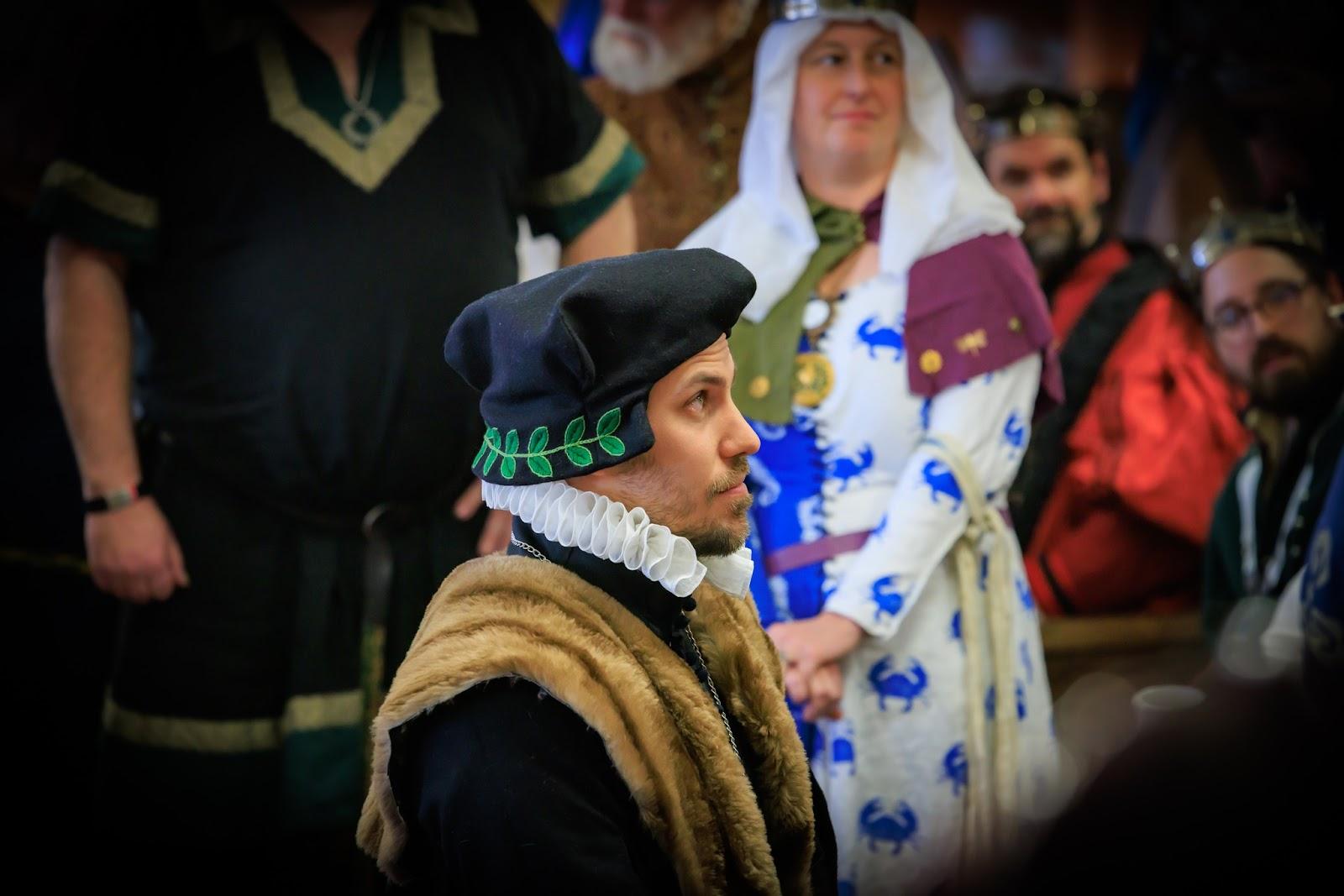 Photo of me during my Elevation in Court, by Thomas Beebe. The square-sewn "Scholar's Cap" and furred "Scholar's Coat" are symbolic of University and clerical scholars on the time- the scholar's cap evolved into the square board cap used in graduation ceremonies today. These were the perfect symbols of this peerage for my persona.