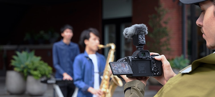 Image of cameraman shooting musicians in unidirectional mode with ECM-B10 attached to the camera.