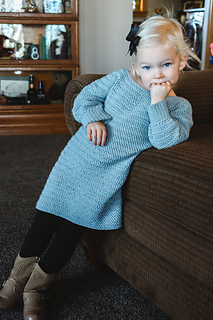 little girl wearing a long sleeve sweater dress