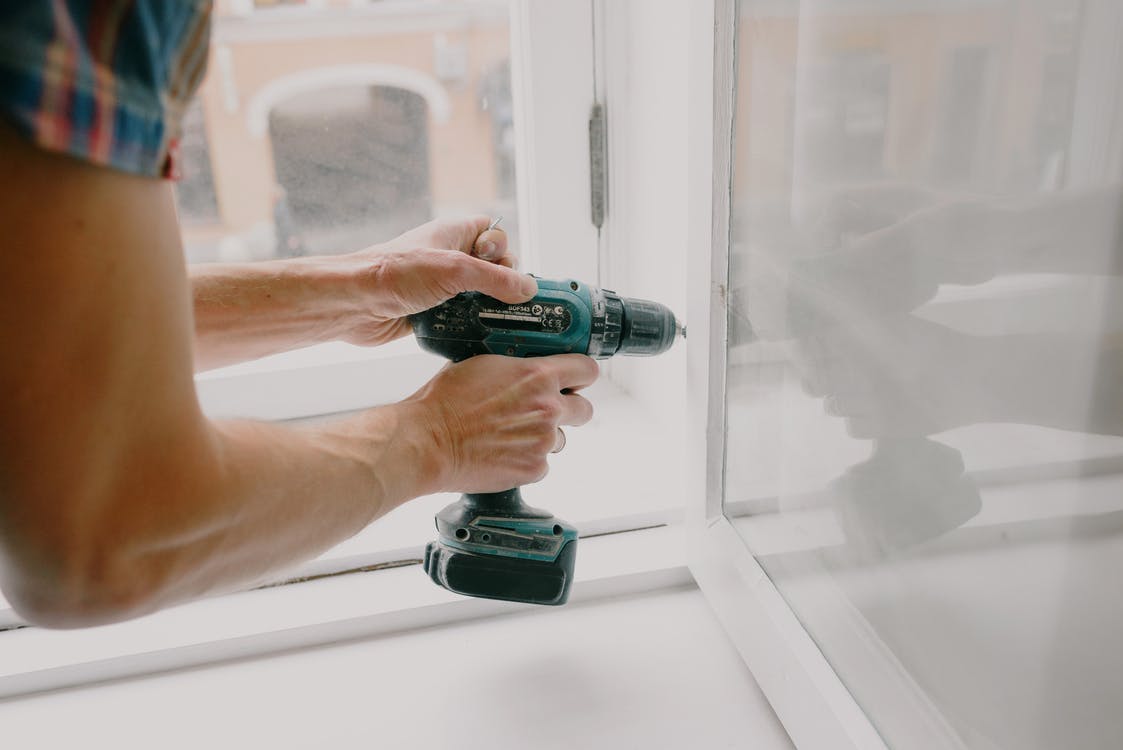 Free Workman screwing window frame during housework Stock Photo