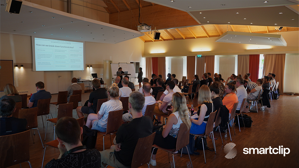 smartclip branded image of employees sitting in a conference hall listening to a presentation.