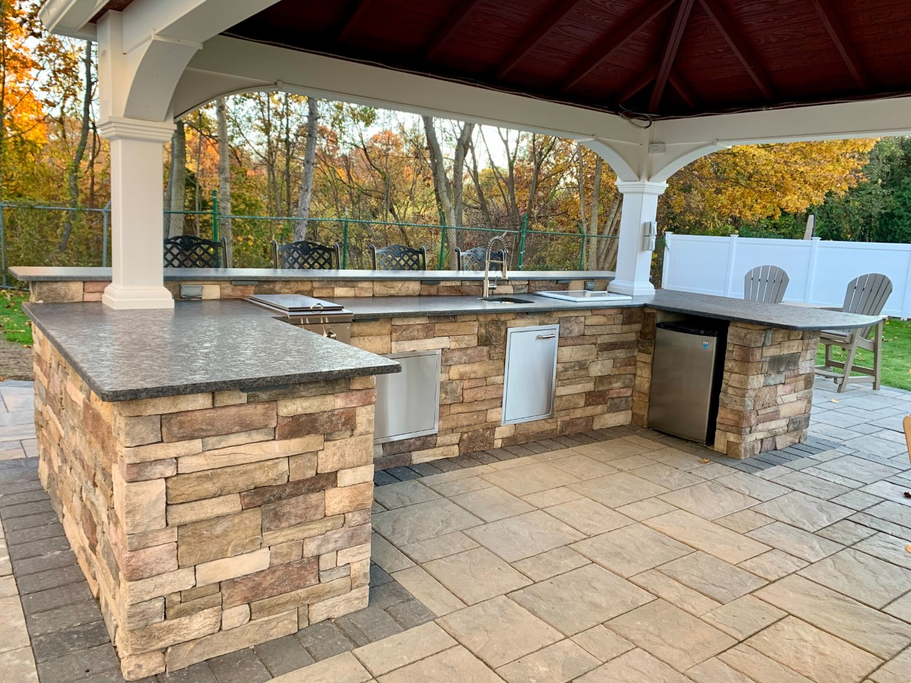 Natural stone pavers and stone veneer are the star of this backyard makeover.