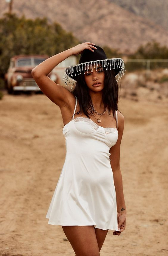 Woman wearing black hat and little white dress