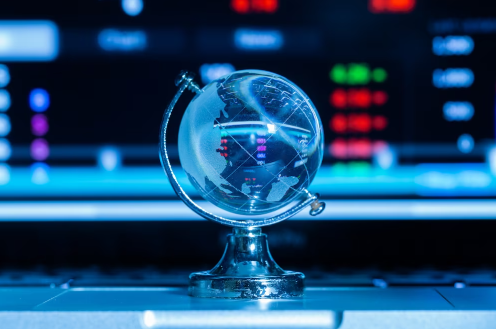 blue glass globe in front of blurred laptop