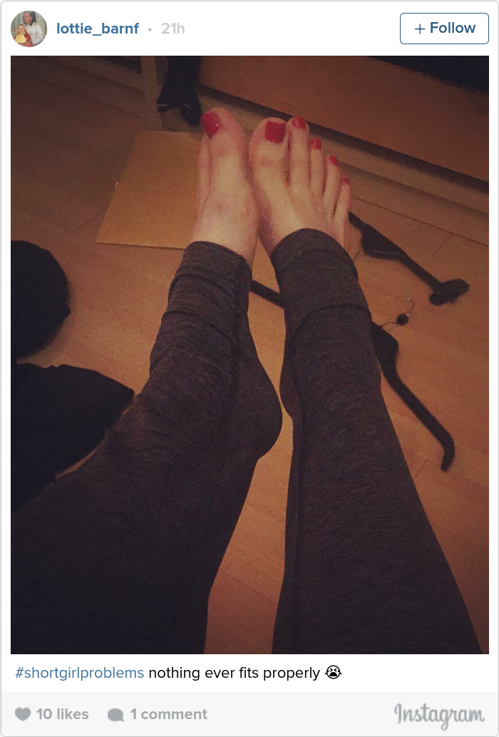 a woman showing that her leggings are way too long for her legs