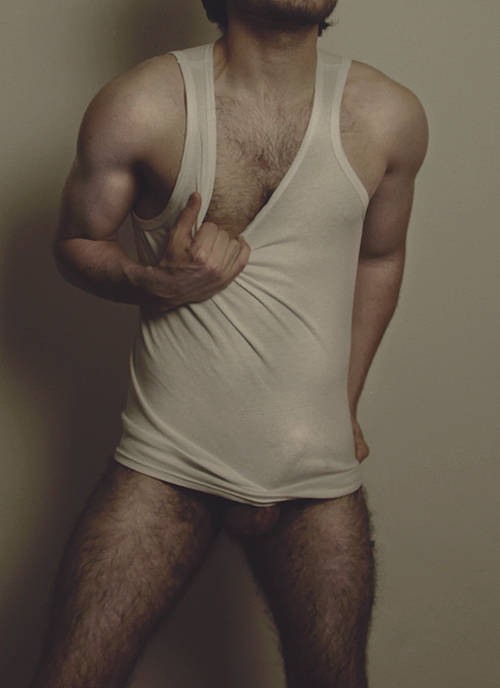 male model posing in a sheer american apparel white tank top while his erect penis pokes through the sheer fabric
