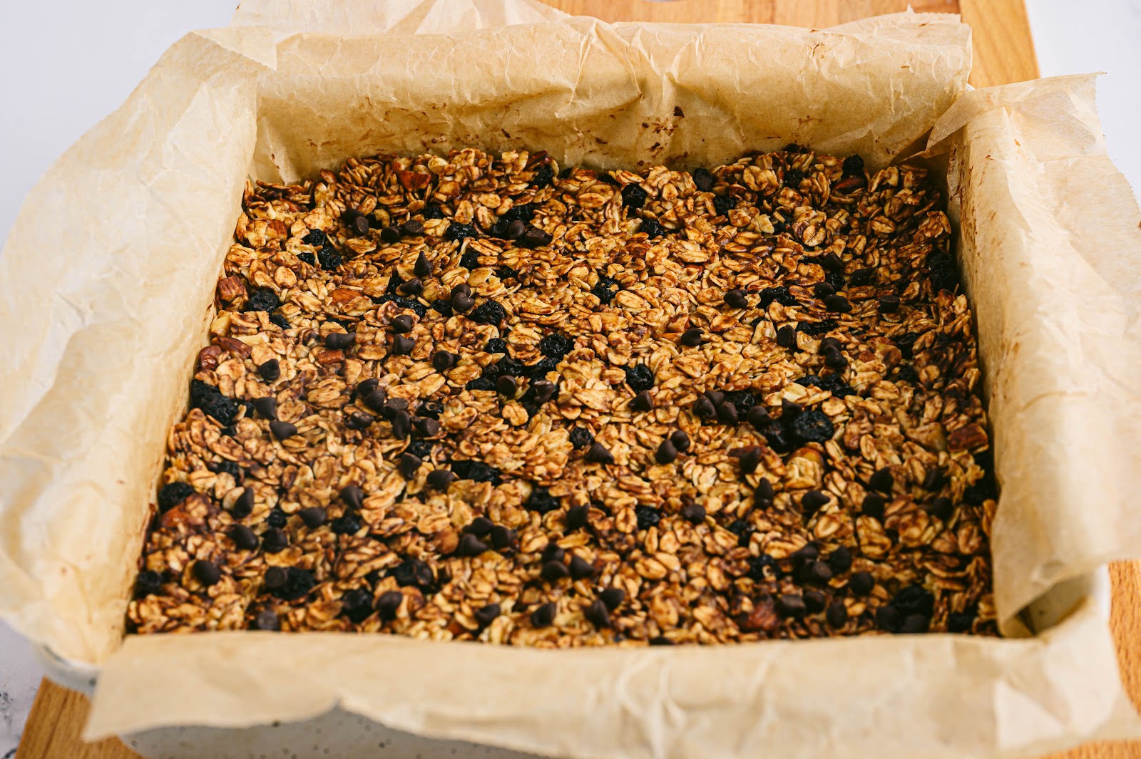 After it’s cooled, pour the entire granola mixture into a lined square baking dish. Let it chill in the fridge for 2 hours.

