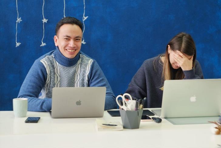 Two people sitting at a table with laptops

Description automatically generated with medium confidence