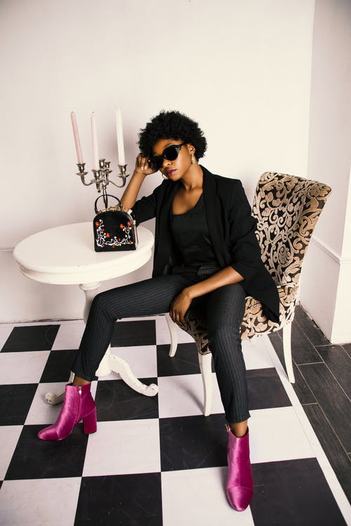 Woman in Black Shirt and Blazer Sitting on White and Brown Wooden Chair