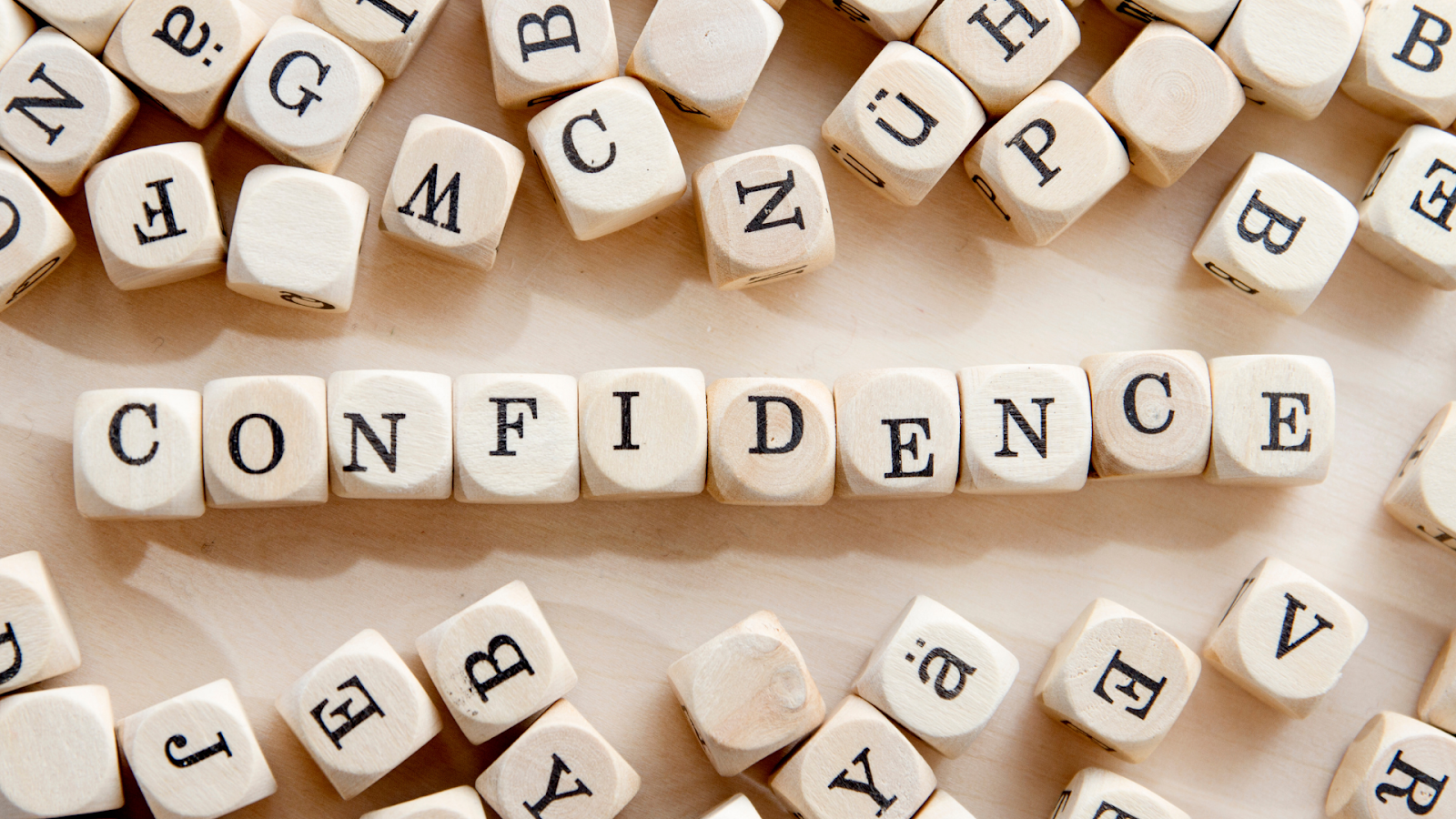 the word confidence spelled out in wooden cubes