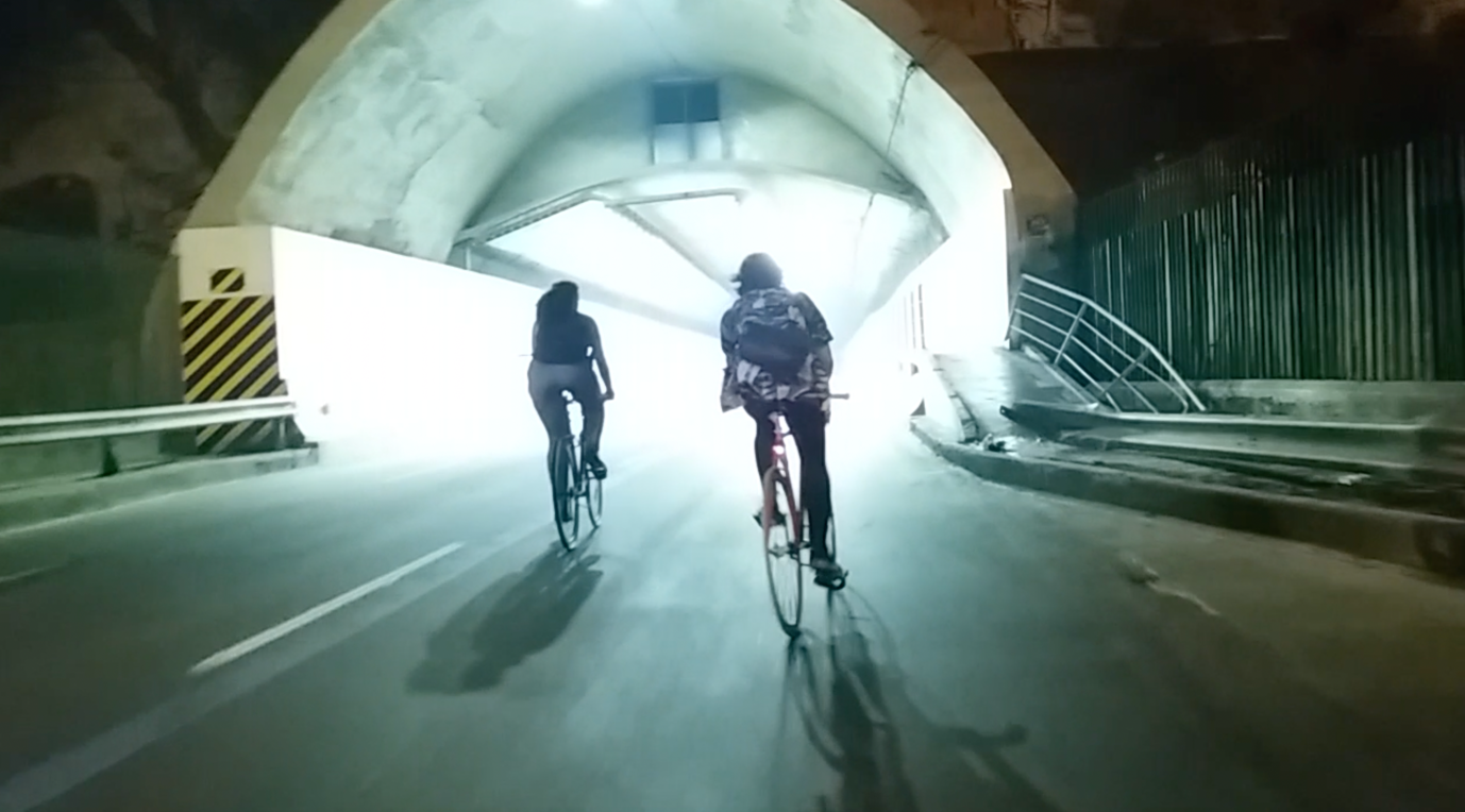 Two people riding bikes in a tunnel

Description automatically generated with medium confidence