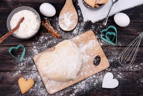 Free Photo | Top view of heart-shaped dough with kitchen utensils
