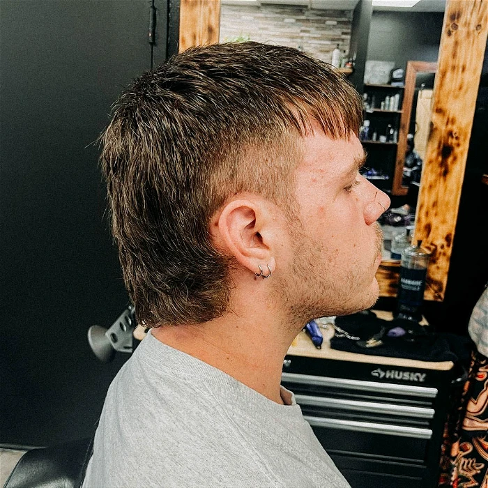 Side view of a guy rocking his mullet with bangs