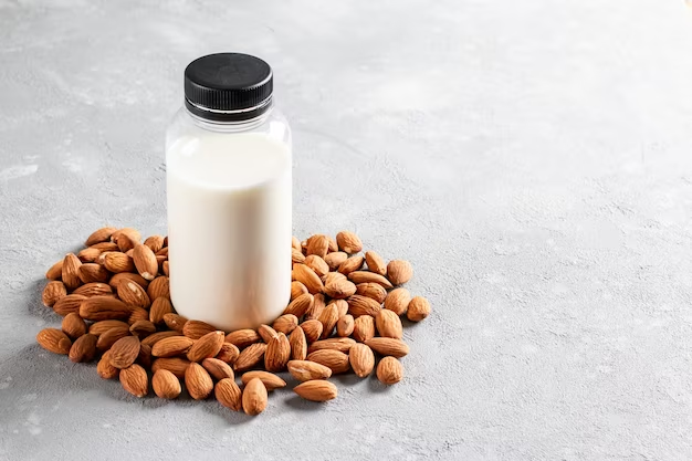 almond milk bottle with almonds light gray background