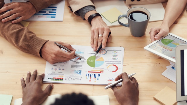 People sitting at a table reviewing business graphs 