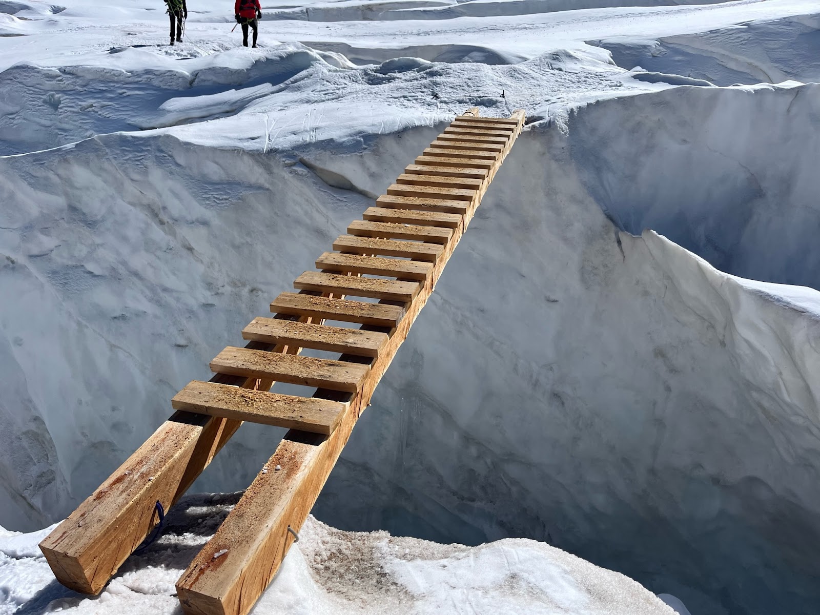 A wooden ladder bridging an ice crevasse on Gran Paradiso in the Alps.