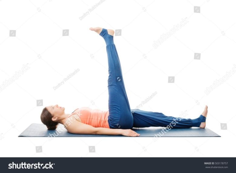 Woman doing yoga asana Uttanpadasana - lying down straight leg raise pose posture isolated on white background