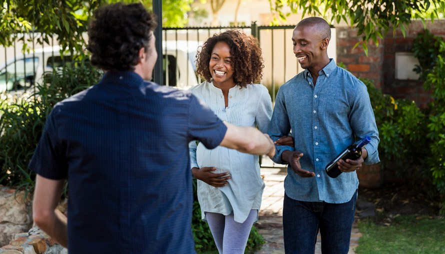 Couple smiling while approaching a man