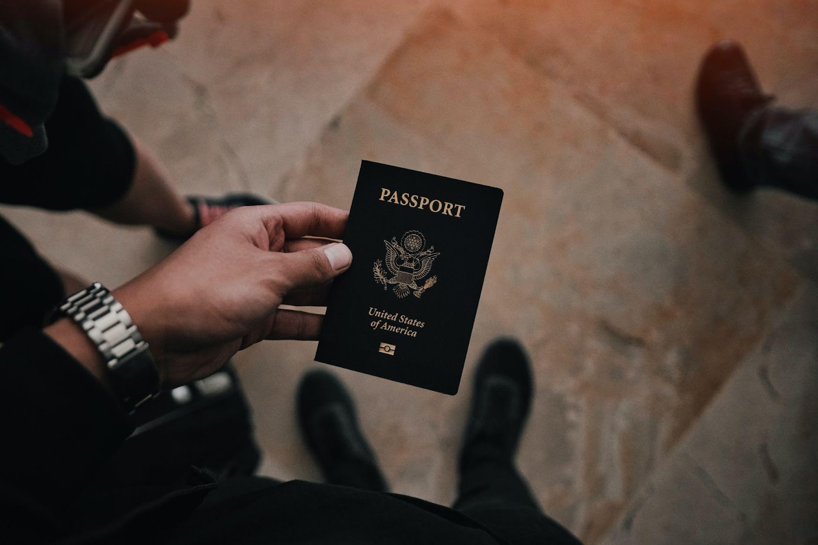 Traveler holds a black U.S passport in his hand