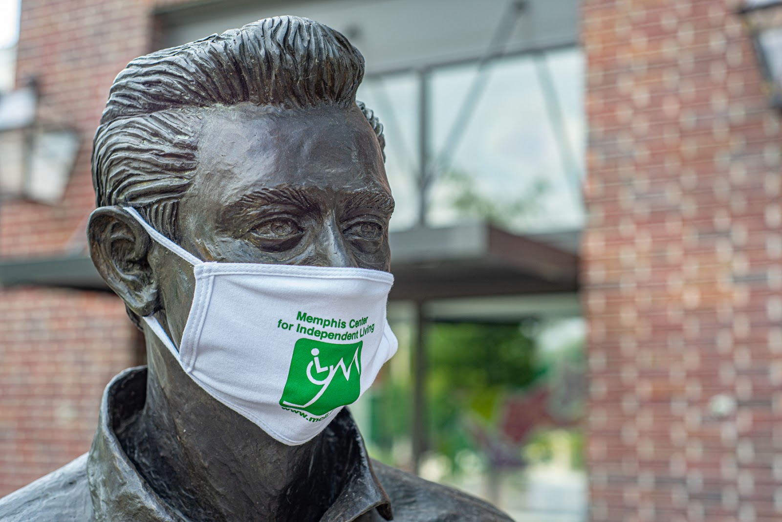 Bronze Statue of Johnny Cash, close-up on his face wearing an MCIL surgical mask. 