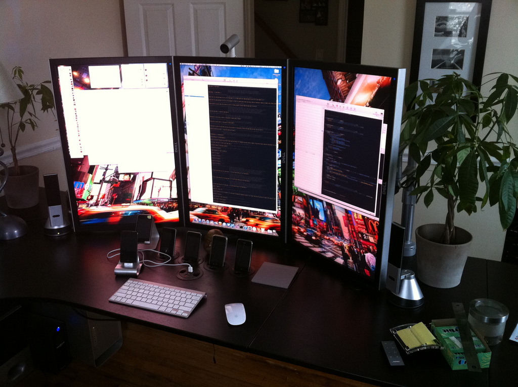 A non-touch (but sideways-oriented) coding setup; a computer setup with three portrait-oriented monitors allows for longer reading instead of cinema format.