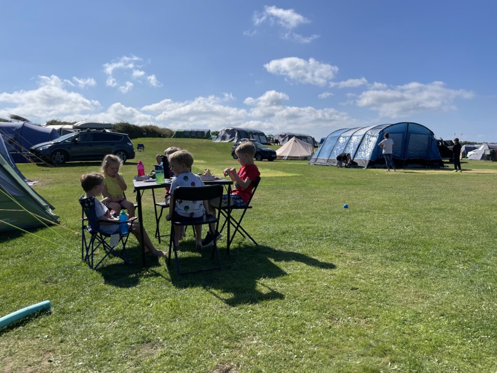 Kids around a table on a campsite
