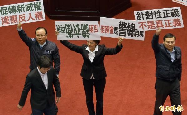 法院院長蘇嘉全5日敲下議事槌，宣布促進轉型正義條例草案三讀通過，國民黨立院黨團立委在議場舉牌抗議該條例。（記者朱沛雄攝）