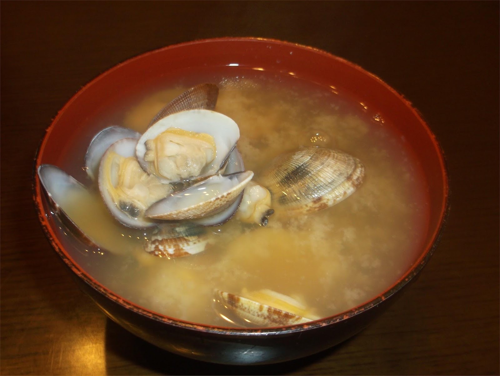 中が赤い漆塗りの汁椀に入ったアサリの味噌汁の画像です。
