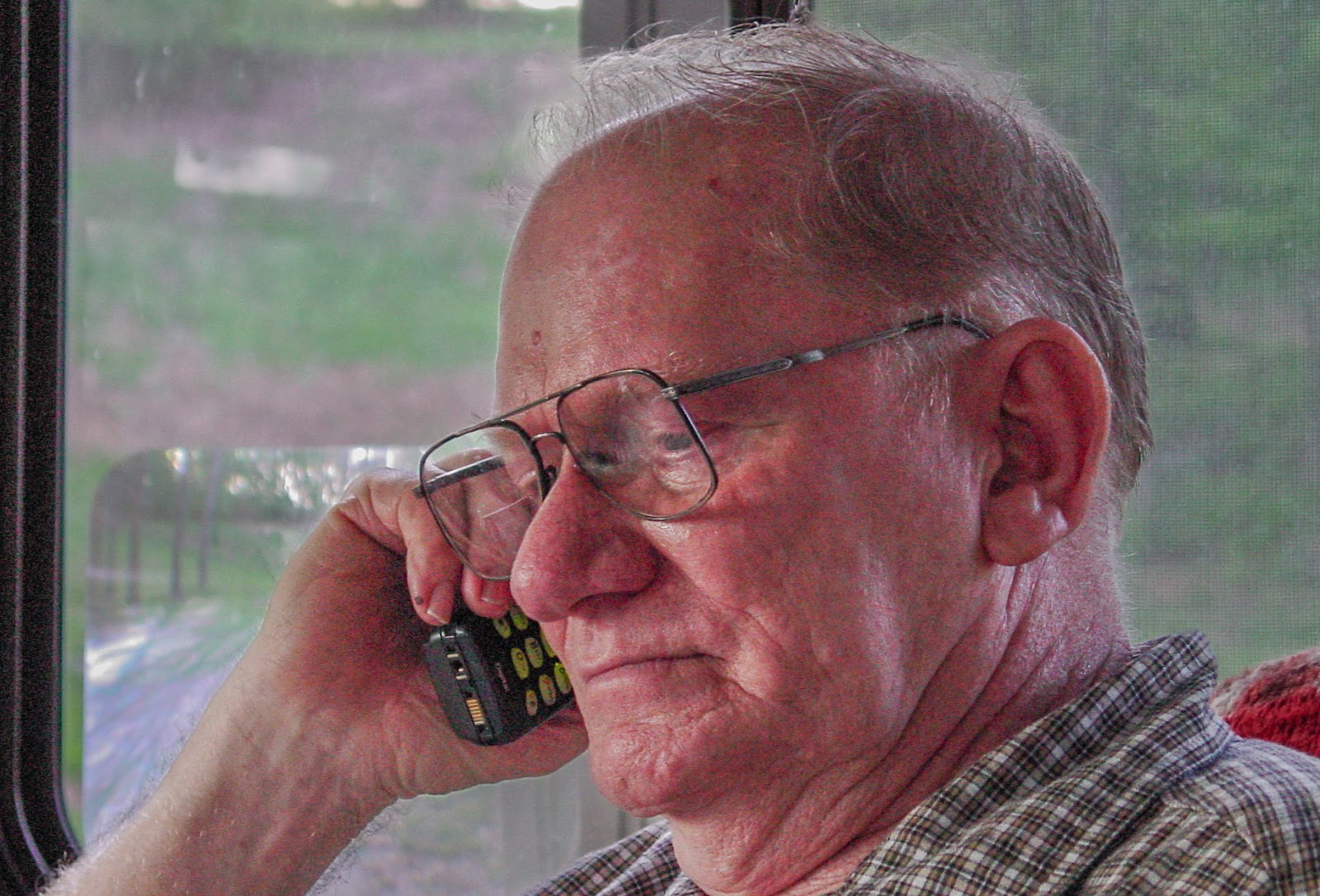 Man in large RV,  listening on a wireless phone. 